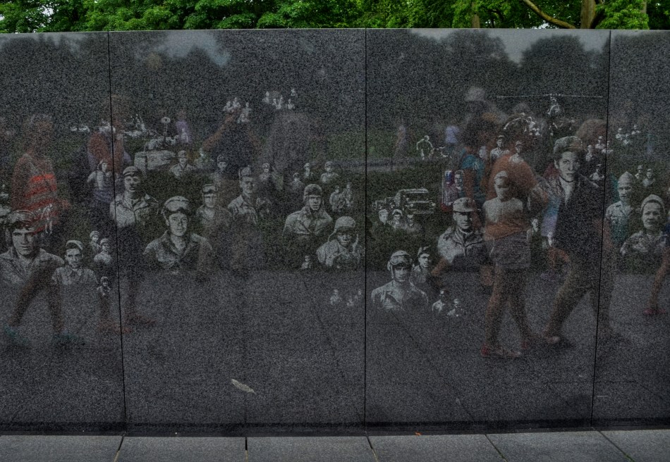 Visitors to the Korean War Memorial pass a wall etched with candid photos of G.I.s from the conflict.