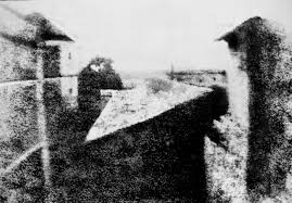 1820's view from the upper floor of Nicéphore Niépce's house is generally acknowledged as the first true photograph, revealing details of a distant pear tree, a slanted barn roof, and the secondary wing of the house (at right).